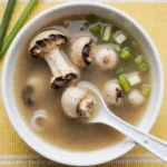 Japanese clear soup recipe with vibrant broth, tofu cubes, shiitake mushrooms, and spring onions, served in a traditional Japanese bowl