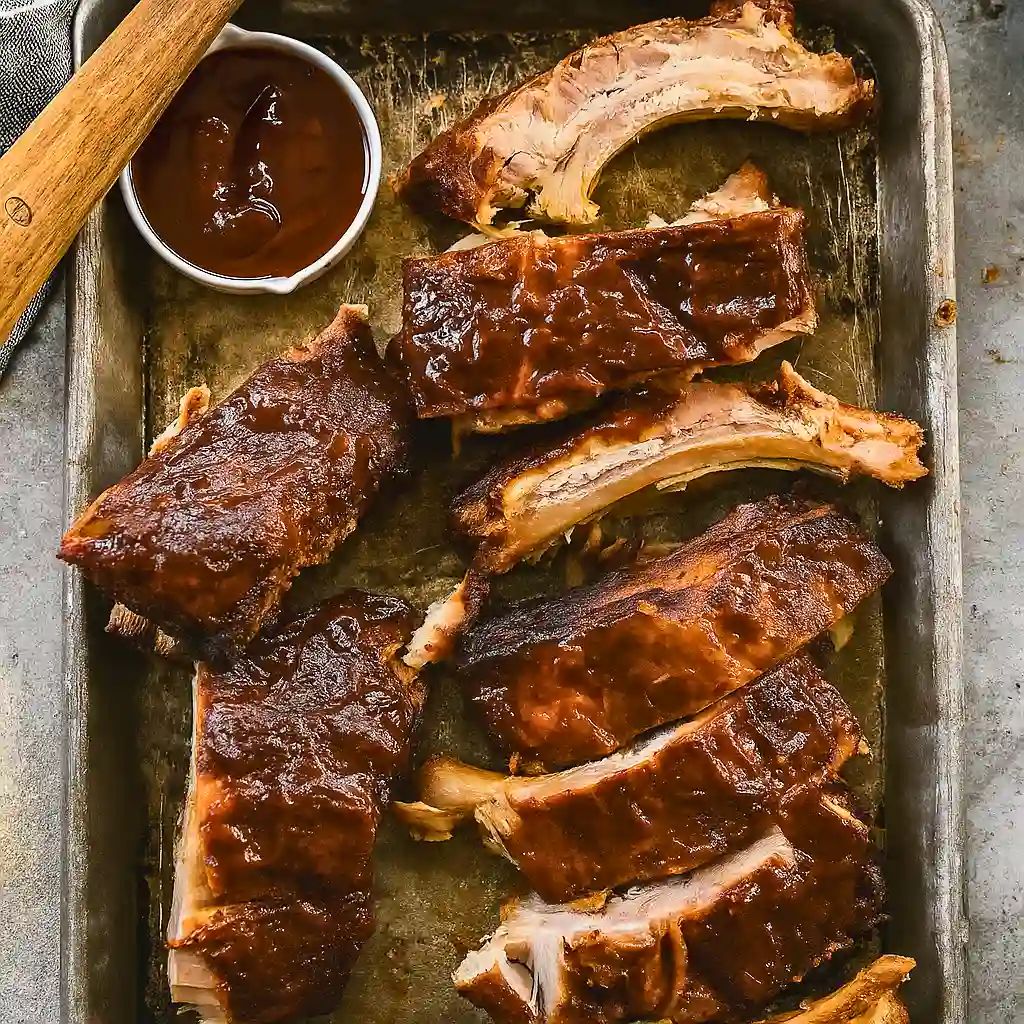 Slow Cooker BBQ Ribs with rich, smoky sauce served with a side of BBQ dipping sauce.