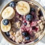A bowl of Blueberry Banana Overnight Oats topped with fresh blueberries and sliced bananas.