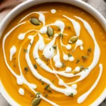 Creamy Coconut Curry Pumpkin Soup garnished with fresh herbs and spices.
