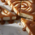 Close-up of a sliced creamy dessert with a graham cracker crust and thick caramel drizzle, a rich alternative to a fresh 5 ingredient no bake lemon tart.