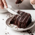 A person using a silver fork to lift a bite of moist Chocolate Espresso Cake, showing the soft crumb texture and dark Easy Chocolate Espresso Cake frosting.