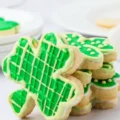 A close-up of a stack of homemade shamrock-shaped sugar cookies decorated with bright green icing in plaid and dotted patterns, a great alternative to st patrick's day cookies costco