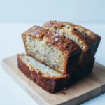 Freshly baked moist banana bread resting on a wire cooling rack after coming out of the oven