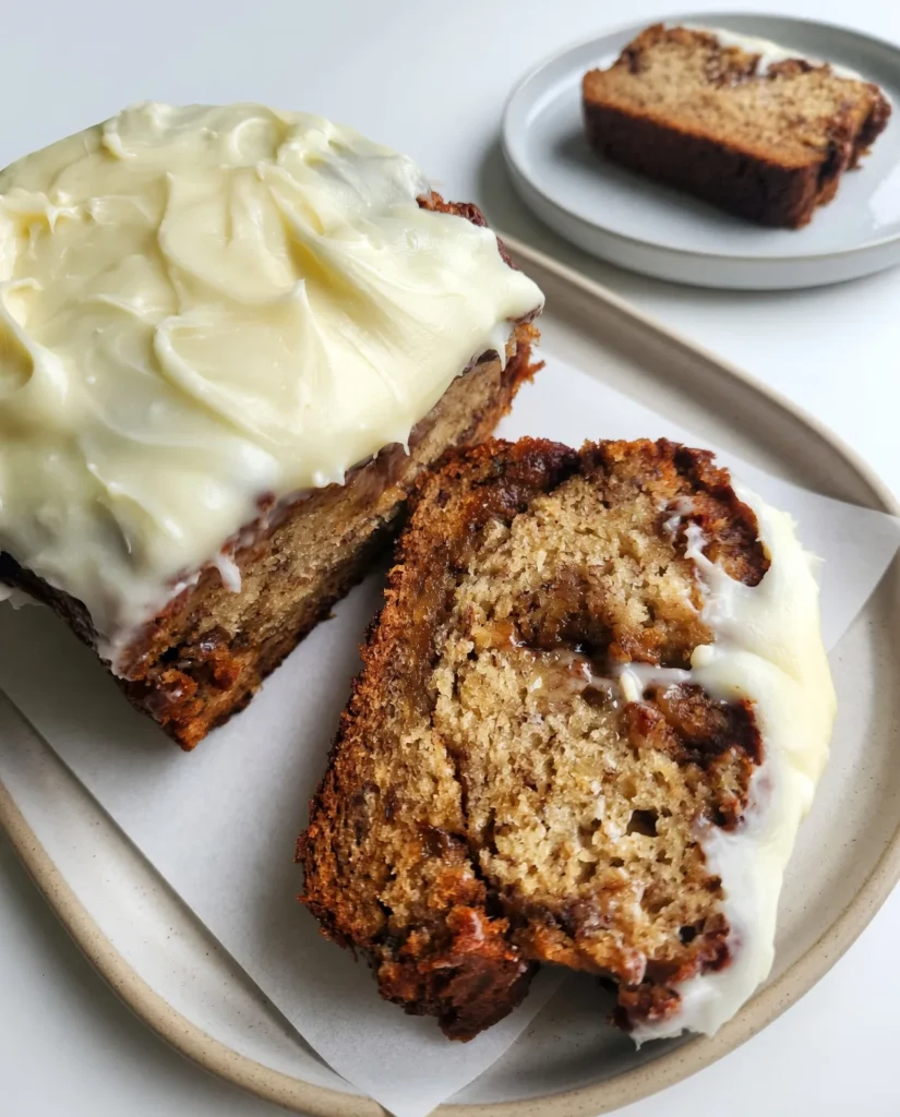 Cinnamon roll banana bread combines ripe bananas, a buttery cinnamon swirl, and rich cream cheese frosting into one irresistible dessert. Try it today!