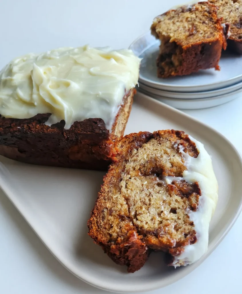 Cinnamon roll banana bread combines ripe bananas, a buttery cinnamon swirl, and rich cream cheese frosting into one irresistible dessert. Try it today!